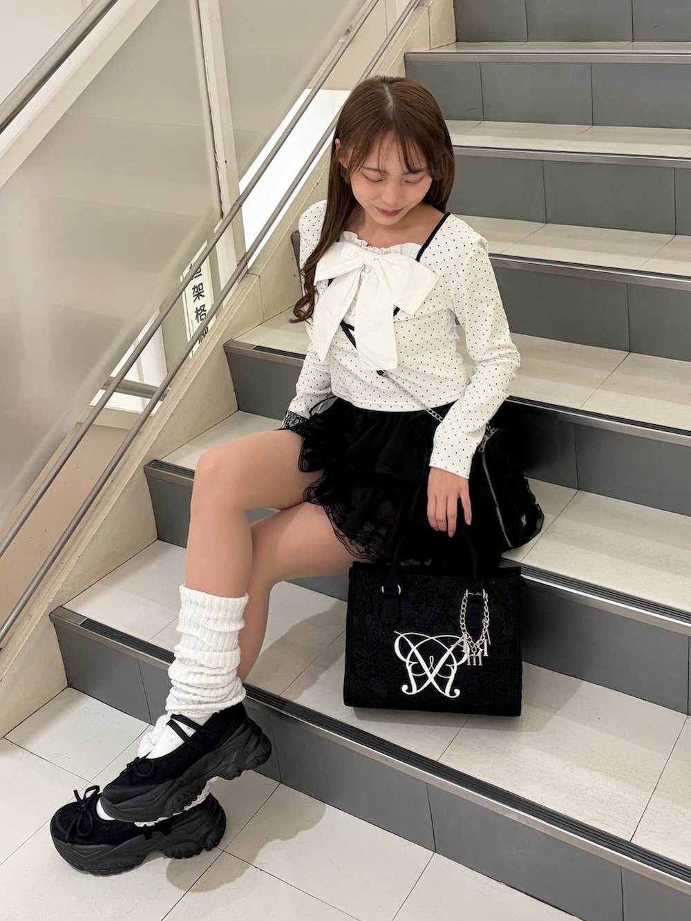 ブラック系のトートバッグ、ブラック系のショルダーバッグ、ブラック系のスカートを着用したレディースの冬コーディネートの2枚目の写真