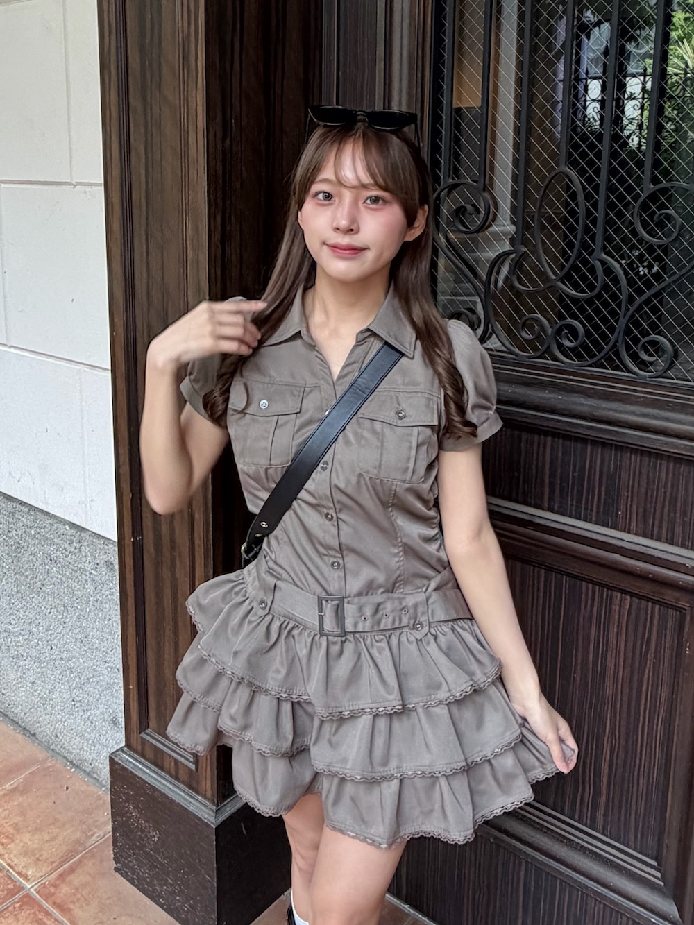グリーン系のワンピース、ブラック系のショルダーバッグ、ブラック系のブーツを着用したレディースの夏コーディネートの2枚目の写真