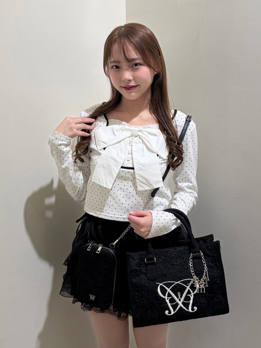 ブラック系のトートバッグ、ブラック系のショルダーバッグ、ブラック系のスカートを着用したレディースの冬コーディネートの3枚目の写真