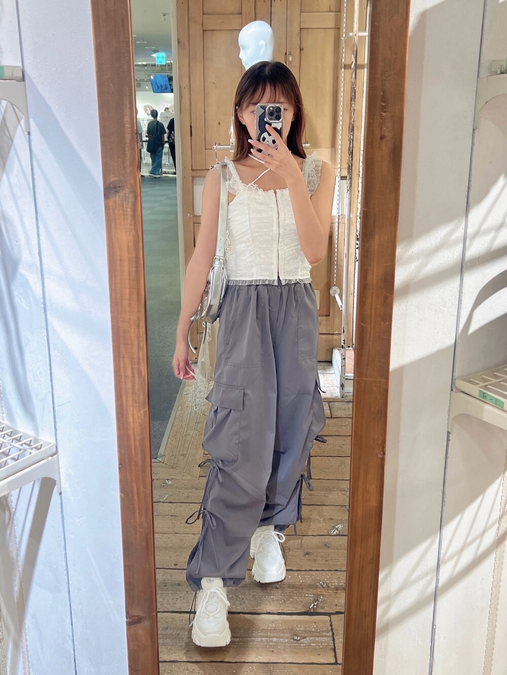 ホワイト系のアンサンブル、ホワイト系のキャミソール、グレー系のカーゴパンツを着用したレディースの夏コーディネートの3枚目の写真