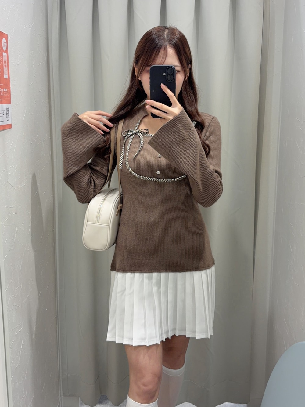 ブラウン系のワンピース、ブラウン系のローファー、ホワイト系のボストンバッグを着用したレディースの秋コーディネートの3枚目の写真