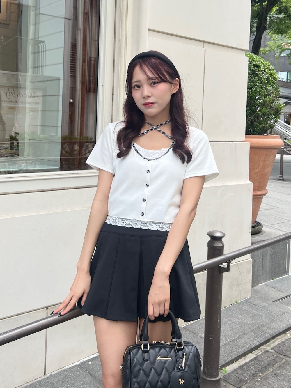 ホワイト系のTシャツ/カットソー、ブラック系のスカート、ブラック系のボストンバッグを着用したレディースの夏コーディネートの2枚目の写真