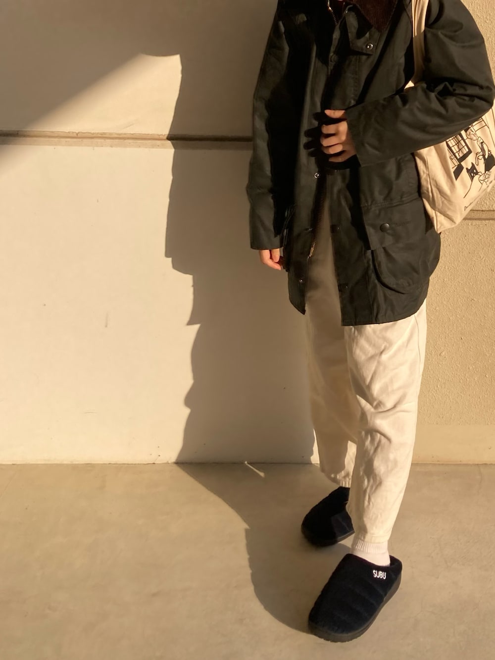 グリーン系のジャケット/アウター、ブルー系のサンダル、ホワイト系のパンツを着用したレディースの冬コーディネートの2枚目の写真