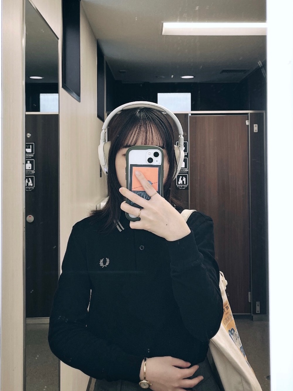 グレー系のスラックス、ブラック系のポロシャツ、ブラック系のドレスシューズを着用したレディースの春コーディネートの2枚目の写真