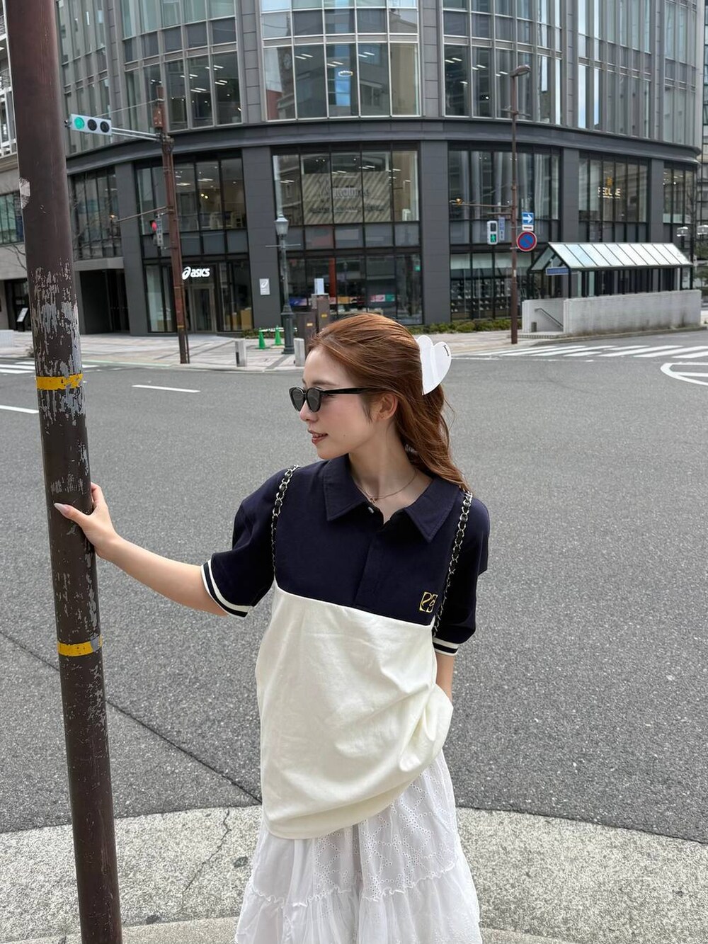 ブラック系のバックパック/リュック、ホワイト系のスカート、ホワイト系のバレッタ/ヘアクリップを着用したレディースの春コーディネートの2枚目の写真