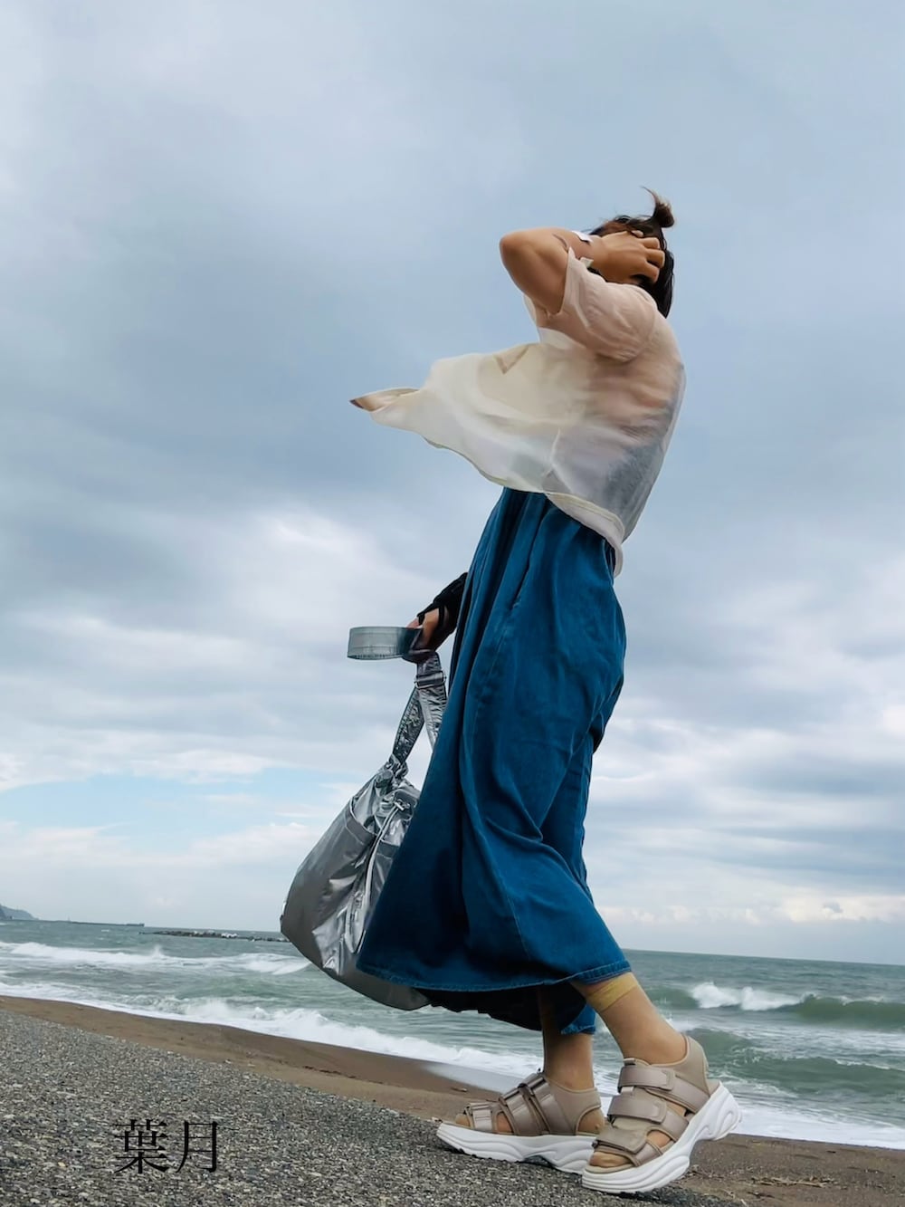 ブルー系のワンピース、ベージュ系のサンダル、シルバー系のショルダーバッグを着用したレディースの夏コーディネートの2枚目の写真