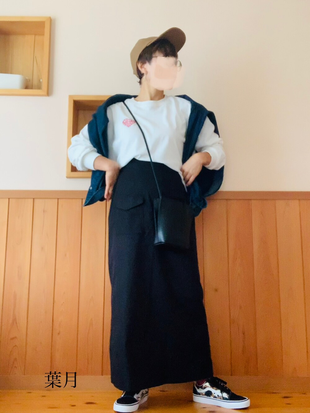 ホワイト系のTシャツ/カットソー、ブラック系のスカート、その他のスニーカーを着用したレディースの秋コーディネートの3枚目の写真