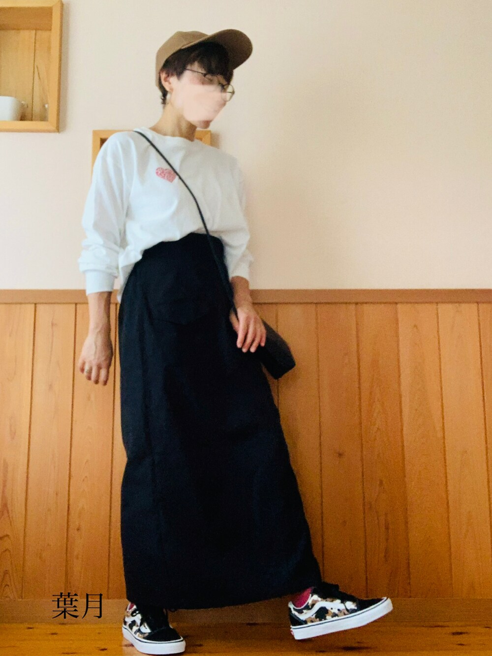 ホワイト系のTシャツ/カットソー、ブラック系のスカート、その他のスニーカーを着用したレディースの秋コーディネートの2枚目の写真