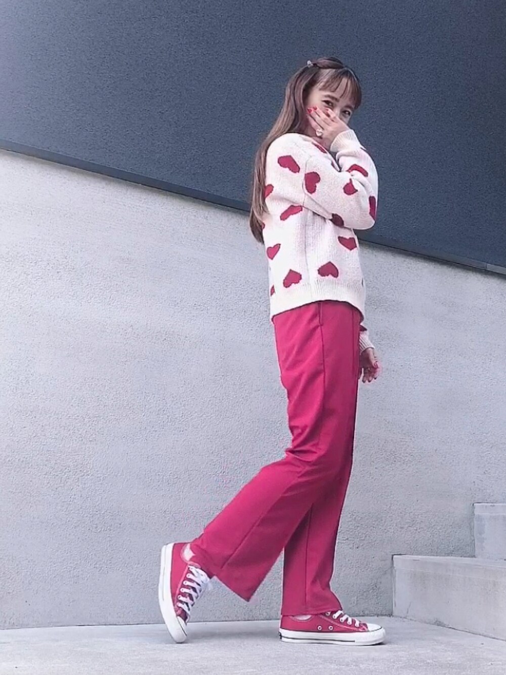 レッド系のニット/セーター、レッド系のパンツ、レッド系のスニーカーを着用したレディースの冬コーディネートの2枚目の写真