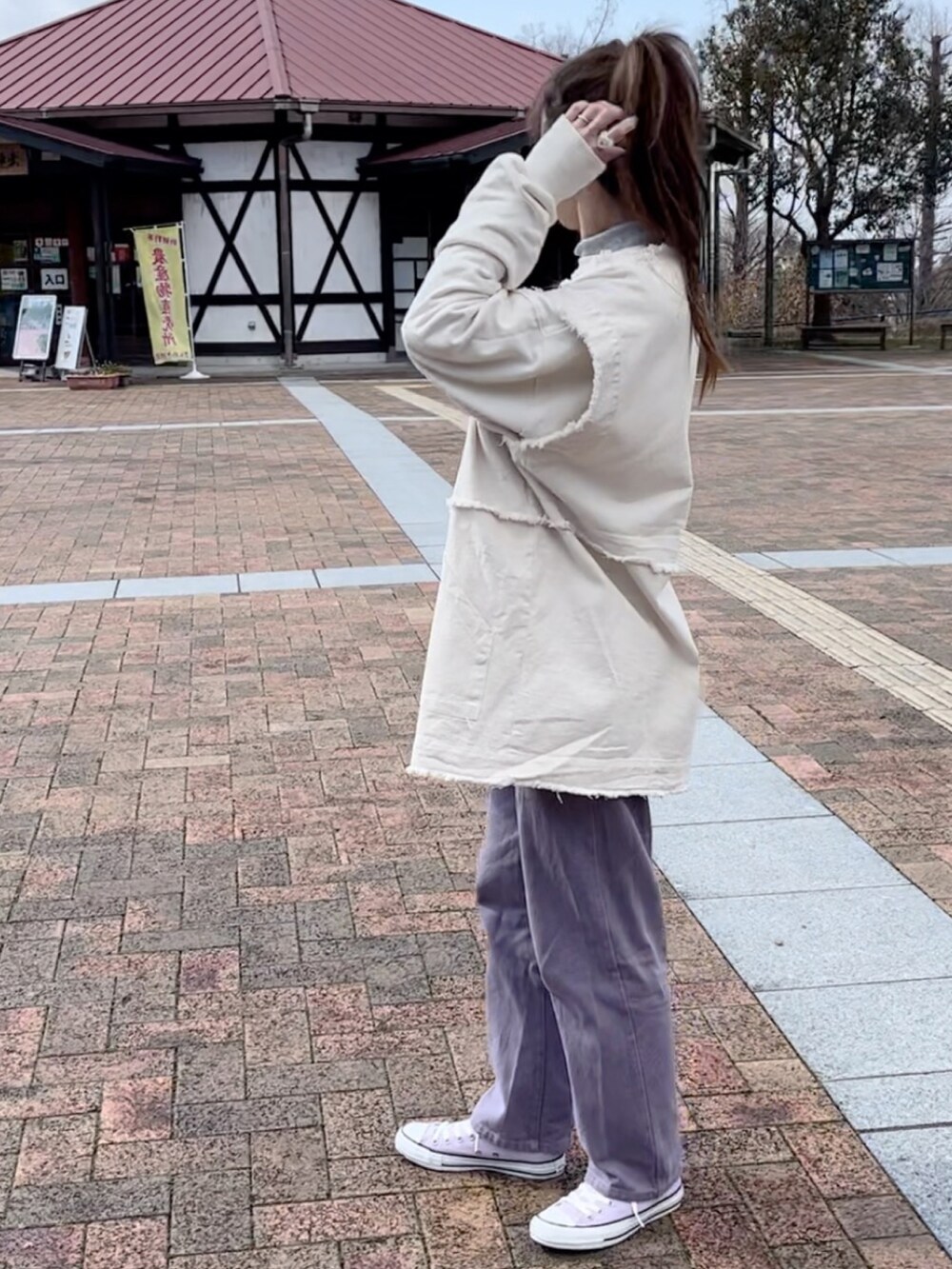 パープル系のデニムパンツ、ホワイト系のデニムジャケットを着用したレディースの冬コーディネートの2枚目の写真