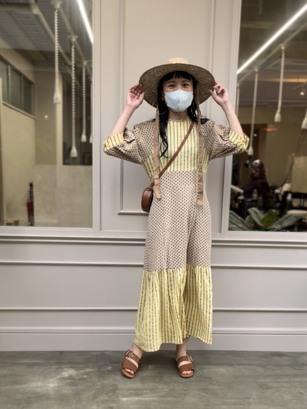 イエロー系のワンピースを着用したレディースの夏コーディネートの2枚目の写真