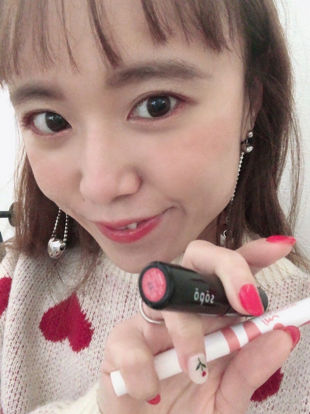 レッド系のニット/セーター、レッド系のパンツ、レッド系のスニーカーを着用したレディースの冬コーディネートの3枚目の写真