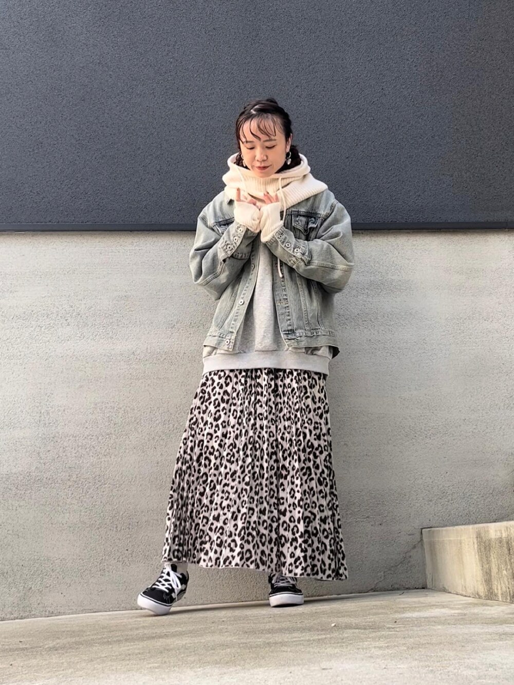 ホワイト系のスカート、ブルー系のデニムジャケット、ブラック系のスニーカーを着用したレディースの秋コーディネートの4枚目の写真