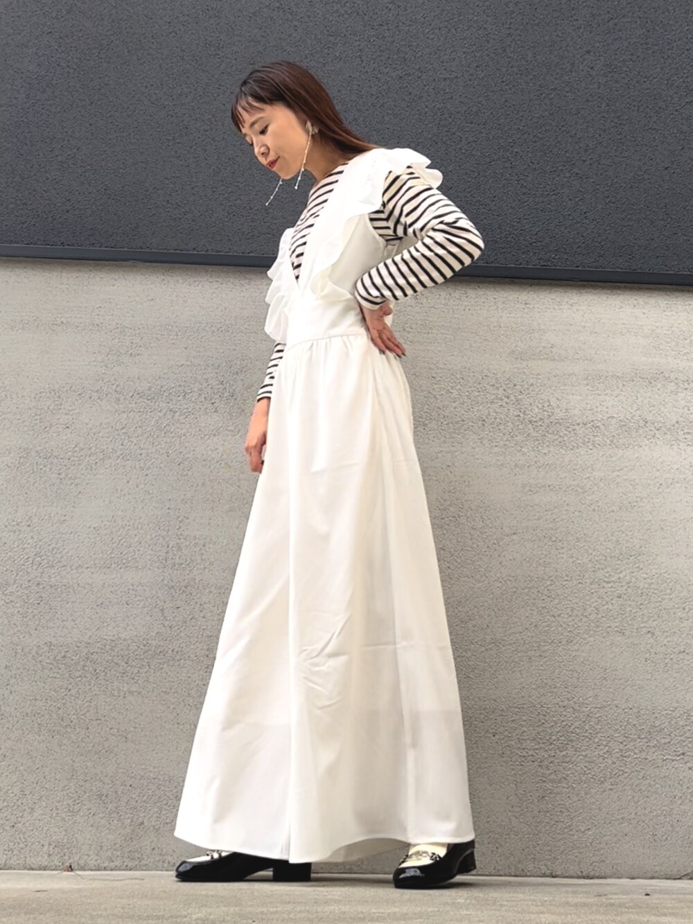 ホワイト系のサロペット/オーバーオール、ホワイト系のTシャツ/カットソー、ブラック系のローファーを着用したレディースの秋コーディネートの2枚目の写真