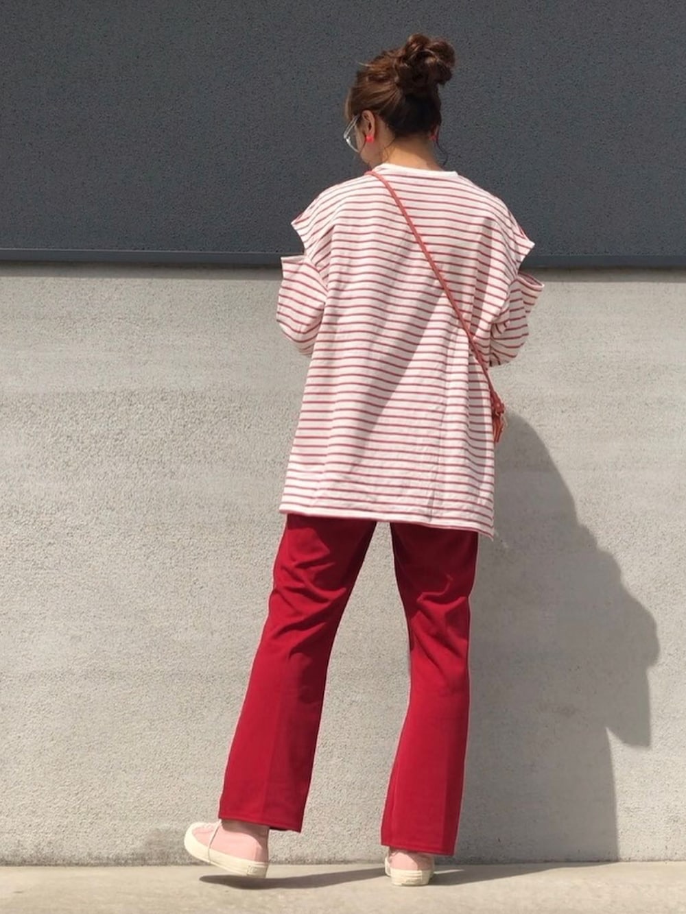 レッド系のパンツ、ピンク系のスニーカー、レッド系のTシャツ/カットソーを着用したレディースの春コーディネートの2枚目の写真