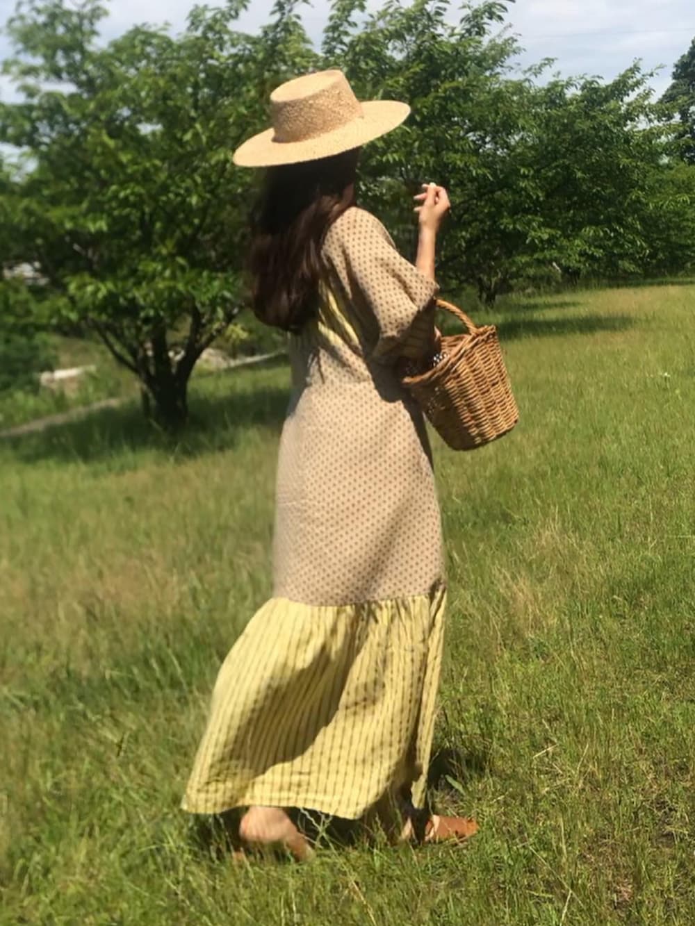 イエロー系のワンピースを着用したレディースの夏コーディネートの3枚目の写真