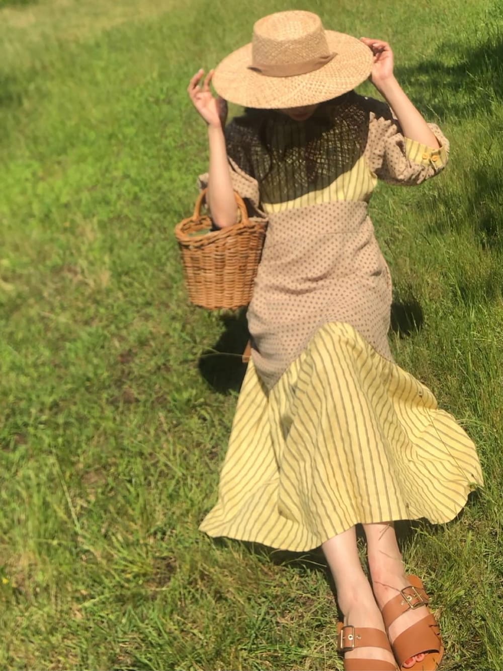 イエロー系のワンピースを着用したレディースの夏コーディネートの2枚目の写真