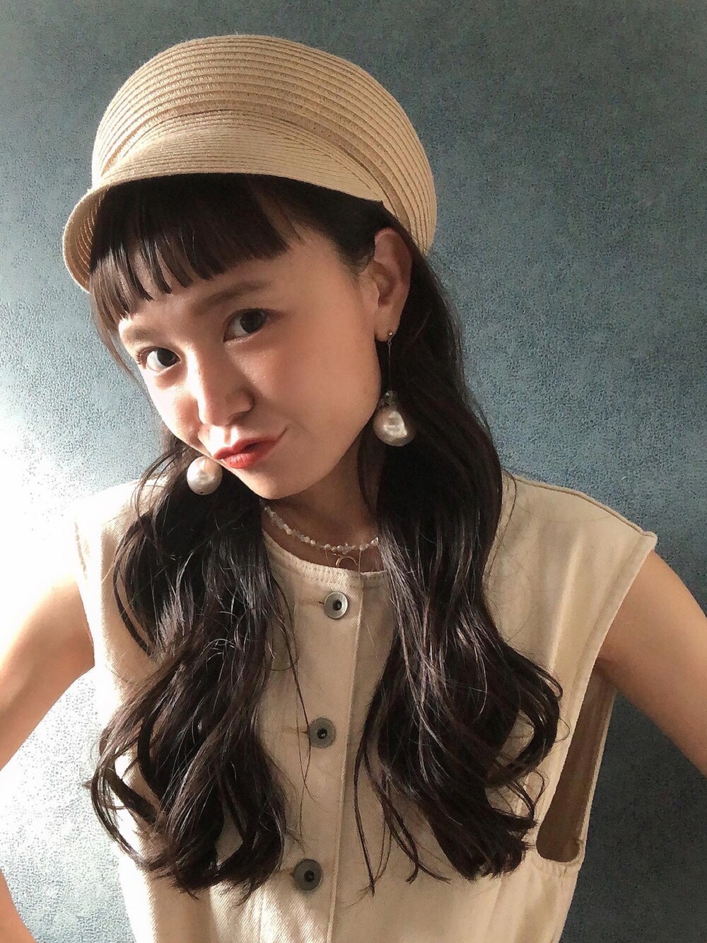 ベージュ系のキャスケットを着用したレディースの夏コーディネートの2枚目の写真