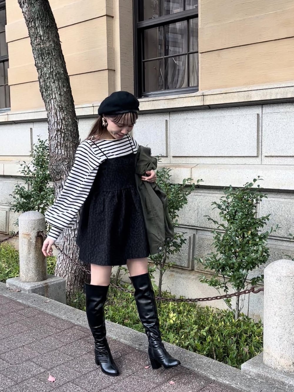 ブラック系のブーツ、グリーン系のノーカラージャケット、ブラック系のキャミソールを着用したレディースの秋コーディネートの2枚目の写真