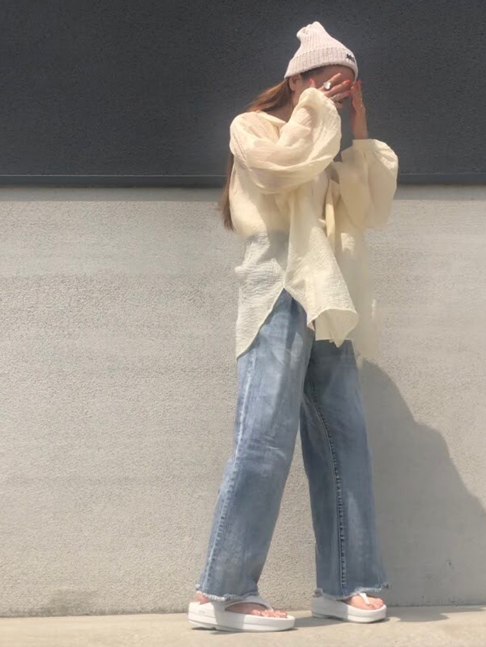 ブルー系のデニムパンツ、ホワイト系のキャミソール、ホワイト系のサンダルを着用したレディースの夏コーディネートの3枚目の写真