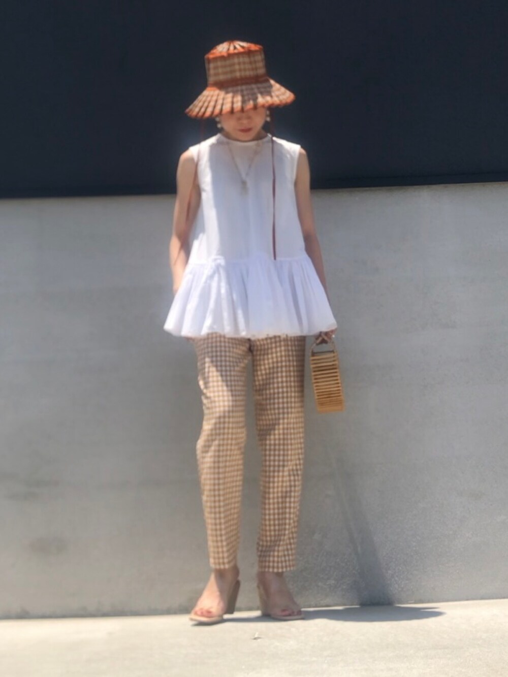 ホワイト系のシャツ/ブラウス、オレンジ系のパンツ、ベージュ系のサンダルを着用したレディースの夏コーディネートの3枚目の写真