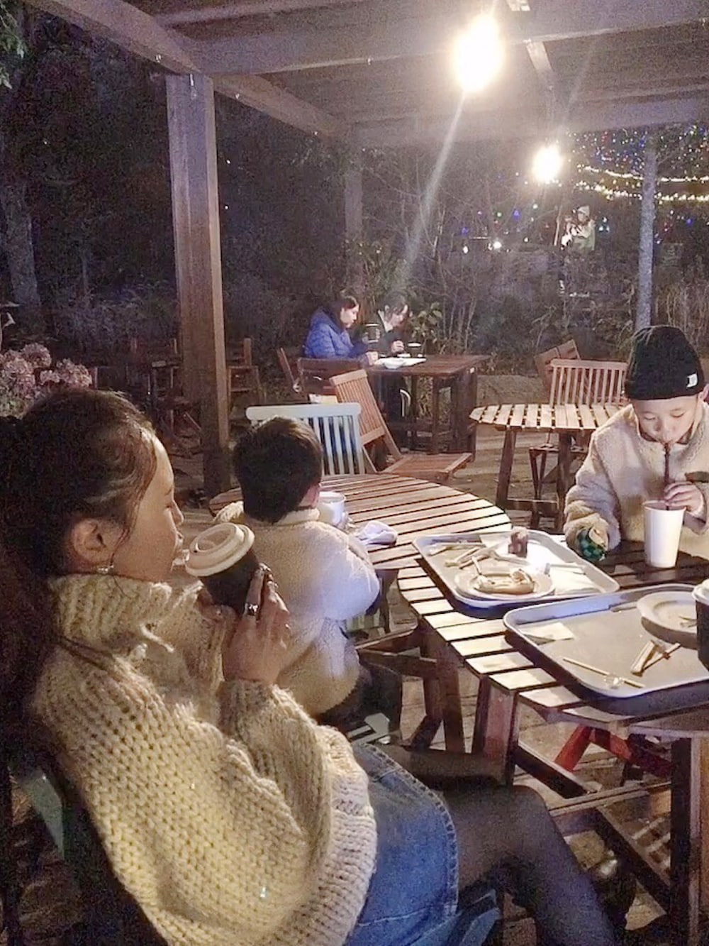 ホワイト系のニット/セーター、ブルー系のデニムスカート、ブラック系のブーツを着用したレディースの秋コーディネートの3枚目の写真