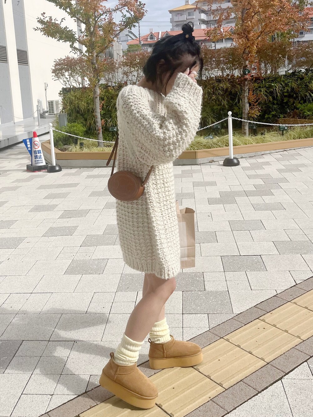 ホワイト系のワンピース、ブラウン系のショルダーバッグ、ブラウン系のシューズを着用したレディースの秋コーディネートの2枚目の写真