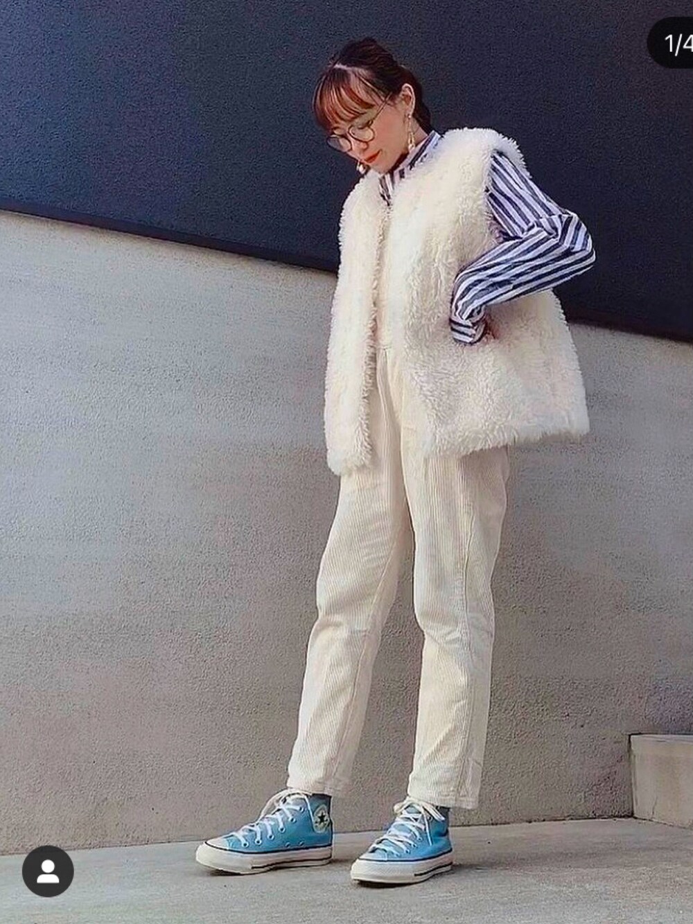 ブルー系のスニーカー、ホワイト系のベスト、ベージュ系のサロペット/オーバーオールを着用したレディースの冬コーディネートの2枚目の写真