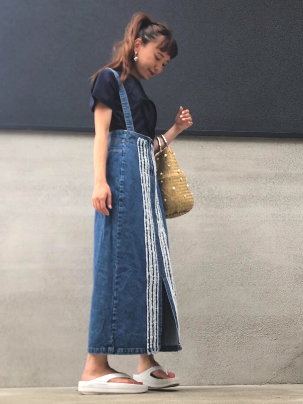 ブルー系のデニムスカート、ホワイト系のサンダル、ブルー系のTシャツ/カットソーを着用したレディースの夏コーディネートの2枚目の写真