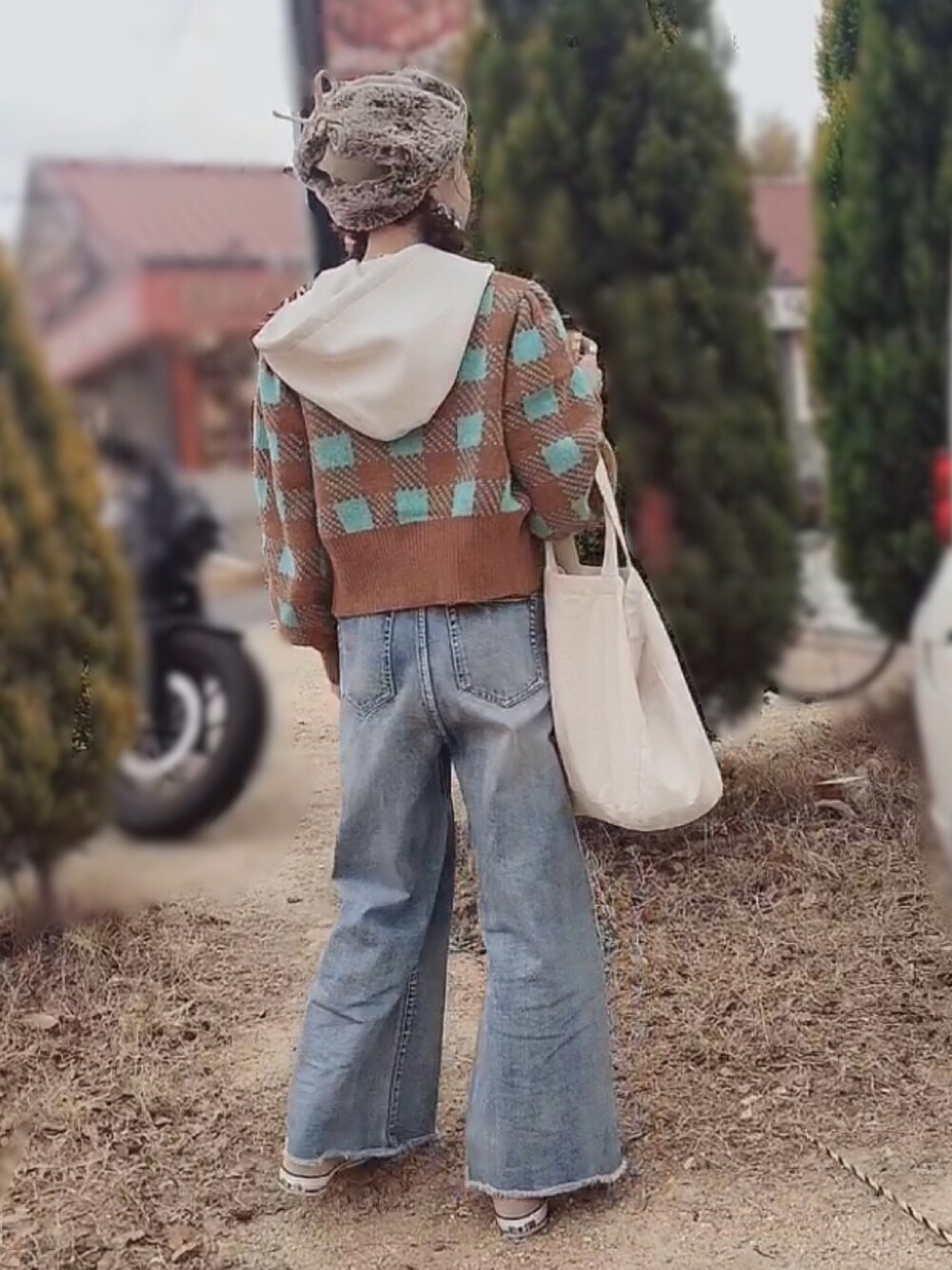 ブルー系のデニムパンツ、ベージュ系のスニーカー、ブラウン系のカーディガン/ボレロを着用したレディースの冬コーディネートの2枚目の写真