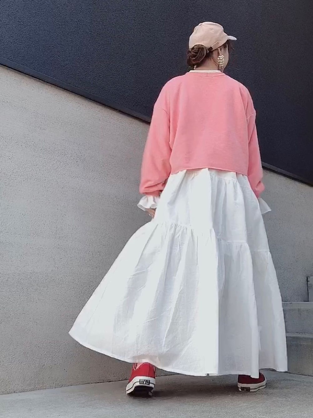 ホワイト系のワンピース、イエロー系のスウェット、レッド系のスニーカーを着用したレディースの冬コーディネートの3枚目の写真