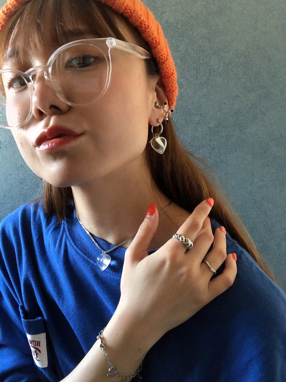 ブルー系のTシャツ/カットソー、ブルー系のデニムパンツ、オレンジ系のニットキャップ/ビーニーを着用したレディースの春コーディネートの2枚目の写真