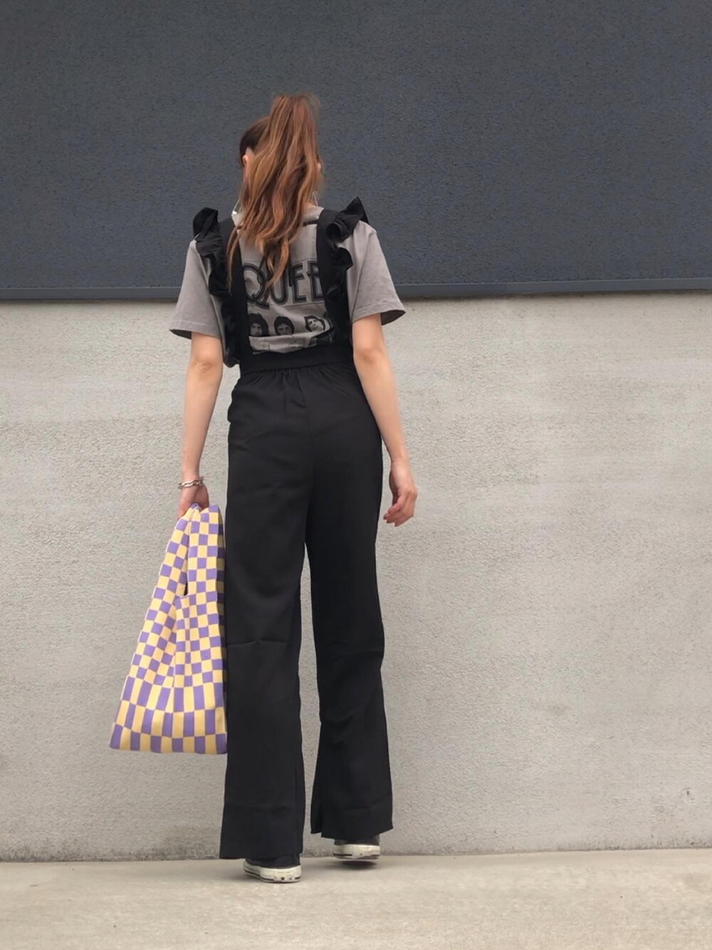 ブラック系のサロペット/オーバーオール、イエロー系のトートバッグ、グレー系のTシャツ/カットソーを着用したレディースの春コーディネートの2枚目の写真