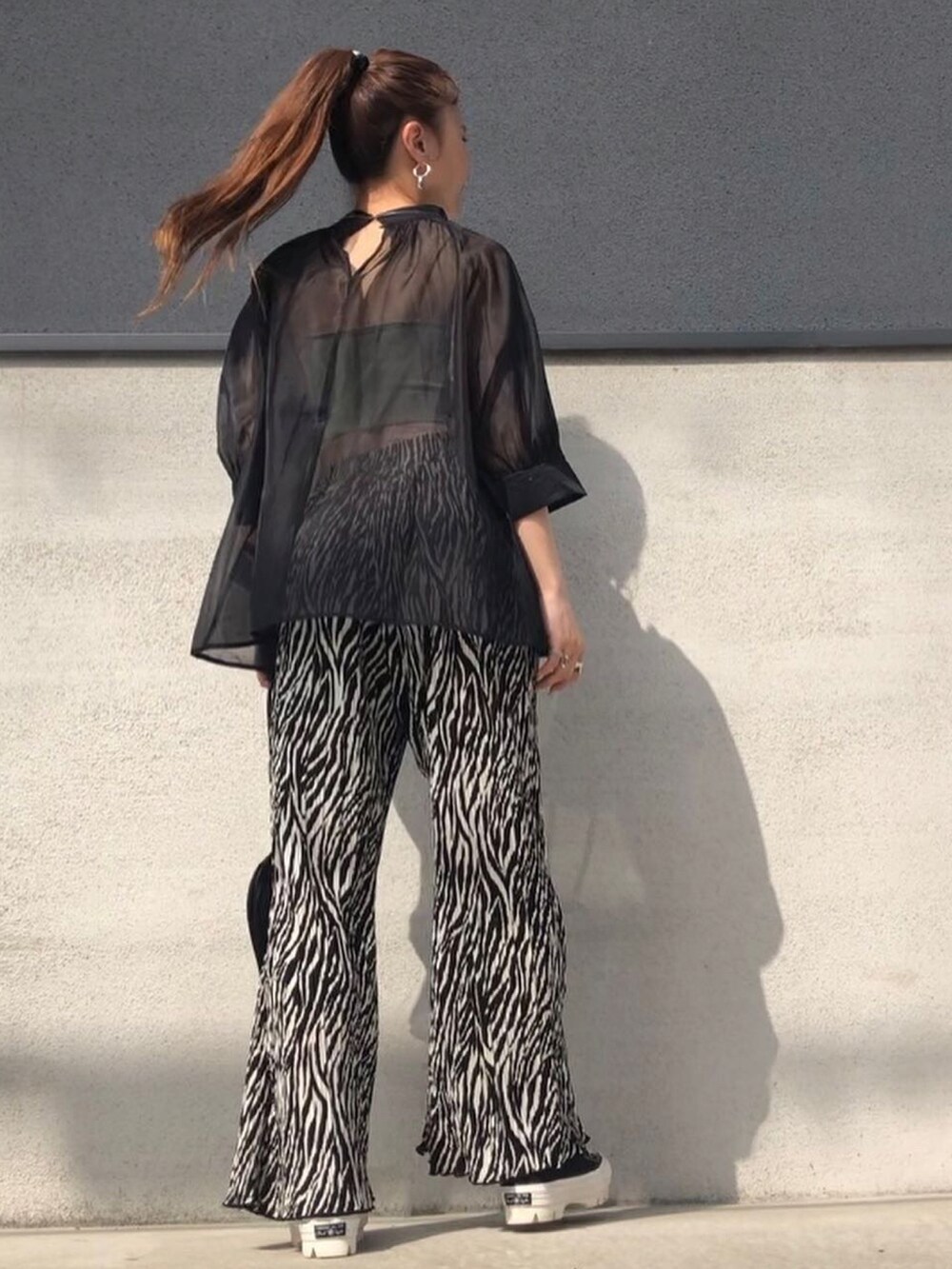 ブラック系のシャツ/ブラウス、ブラック系のパンツ、ブラック系のスニーカーを着用したレディースの春コーディネートの2枚目の写真