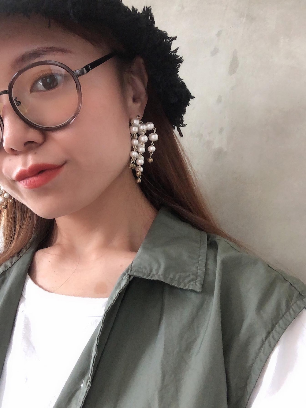 ブルー系のデニムスカート、ブラック系のスニーカー、グリーン系のベストを着用したレディースの夏コーディネートの3枚目の写真