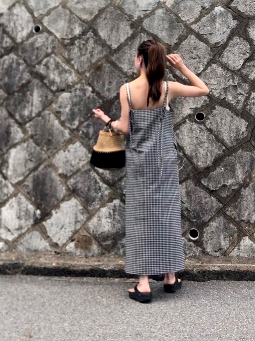 ブラック系のワンピース、ホワイト系のサンダルを着用したレディースの夏コーディネートの3枚目の写真