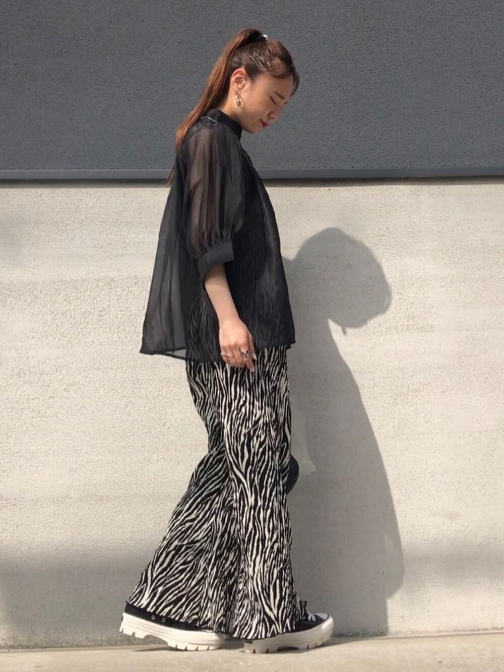 ブラック系のシャツ/ブラウス、ブラック系のパンツ、ブラック系のスニーカーを着用したレディースの春コーディネートの3枚目の写真