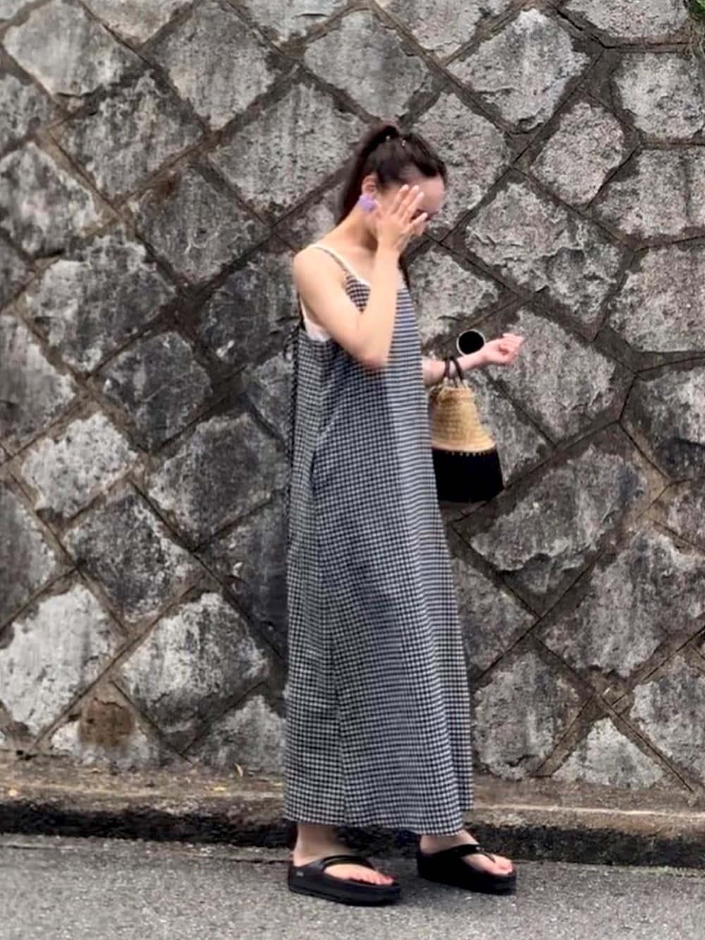 ブラック系のワンピース、ホワイト系のサンダルを着用したレディースの夏コーディネートの2枚目の写真
