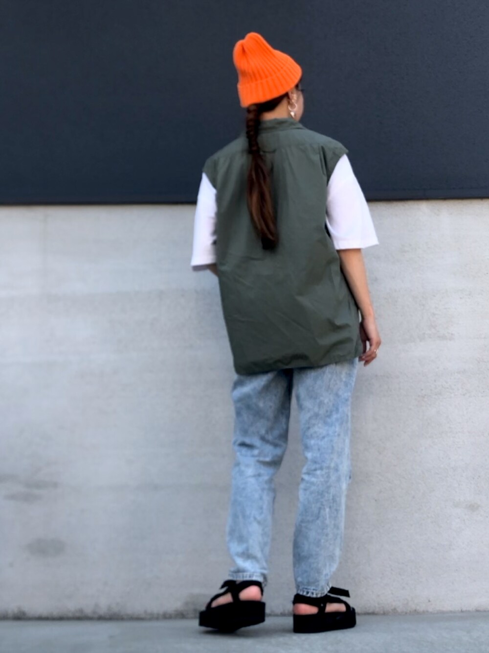 ブルー系のデニムパンツ、ブラック系のサンダル、ホワイト系のTシャツ/カットソーを着用したレディースの夏コーディネートの2枚目の写真