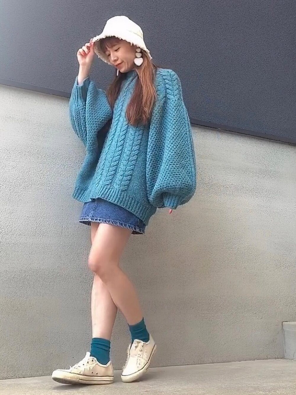 ブルー系のデニムスカート、ブルー系のニット/セーター、ブルー系のソックス/靴下を着用したレディースの冬コーディネートの3枚目の写真