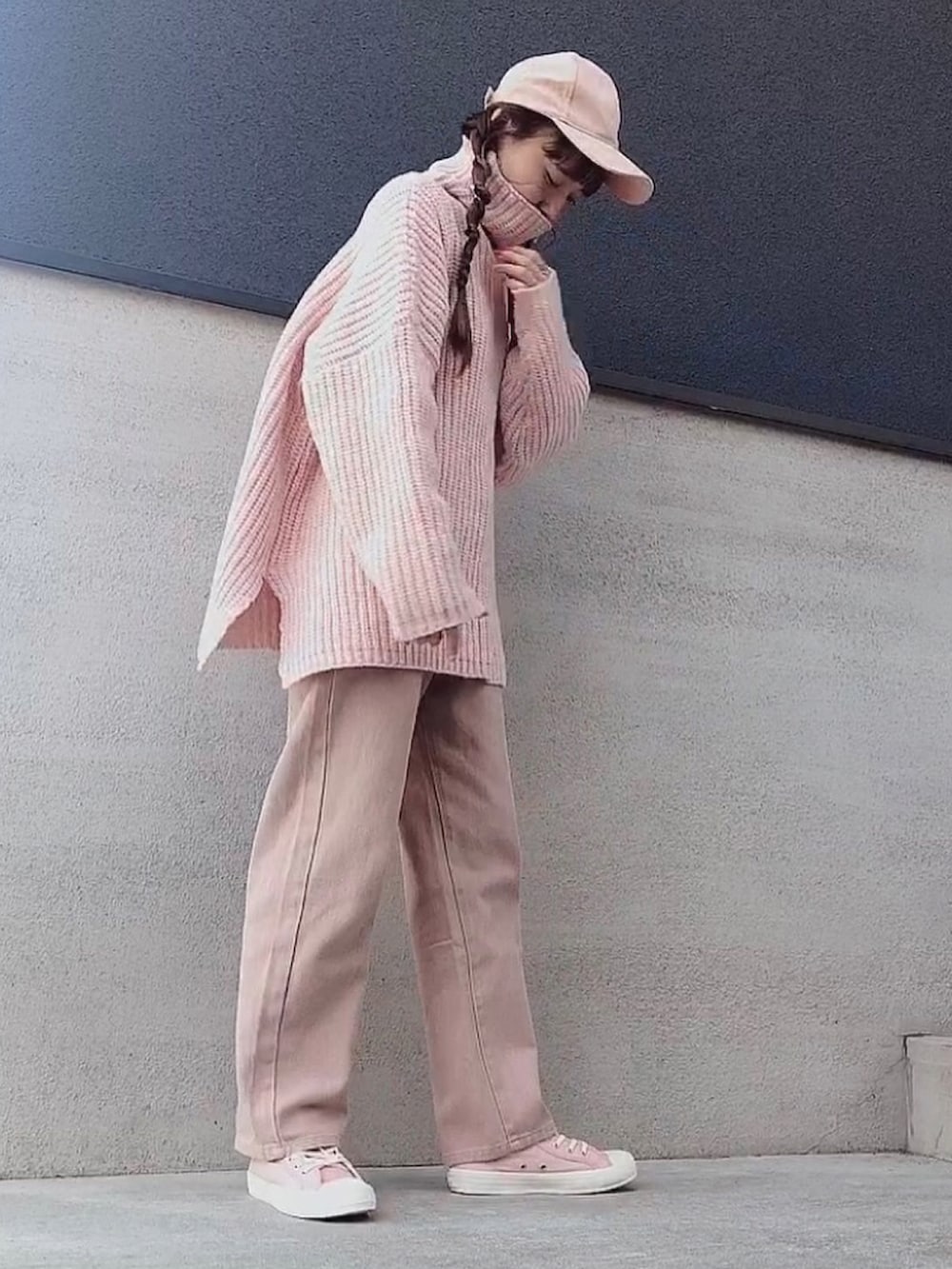 ピンク系のニット/セーター、ピンク系のデニムパンツ、ピンク系のスニーカーを着用したレディースの冬コーディネートの2枚目の写真