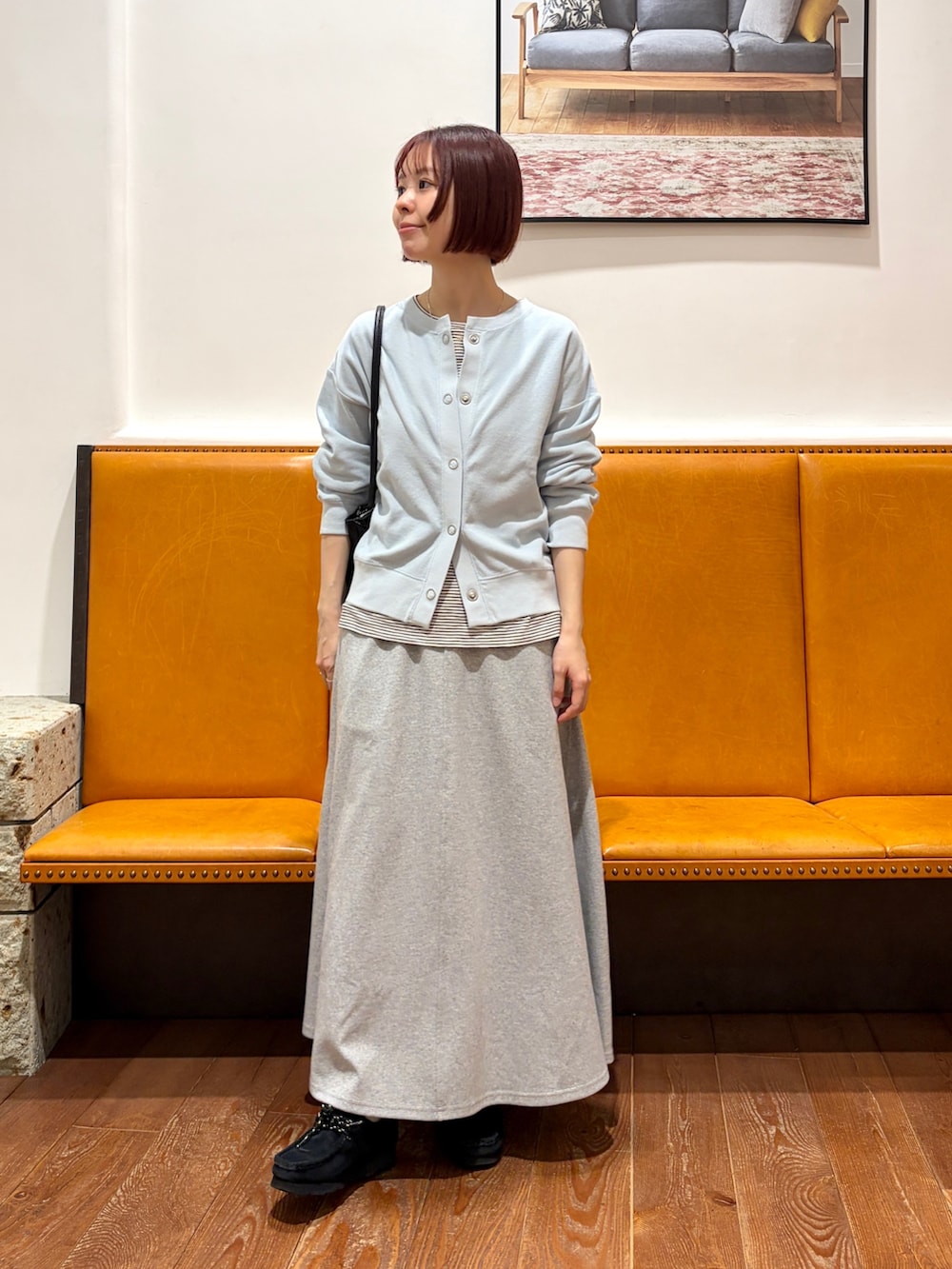 ブルー系のカーディガン/ボレロ、ベージュ系のTシャツ/カットソー、グレー系のスカートを着用したレディースの春コーディネートの2枚目の写真