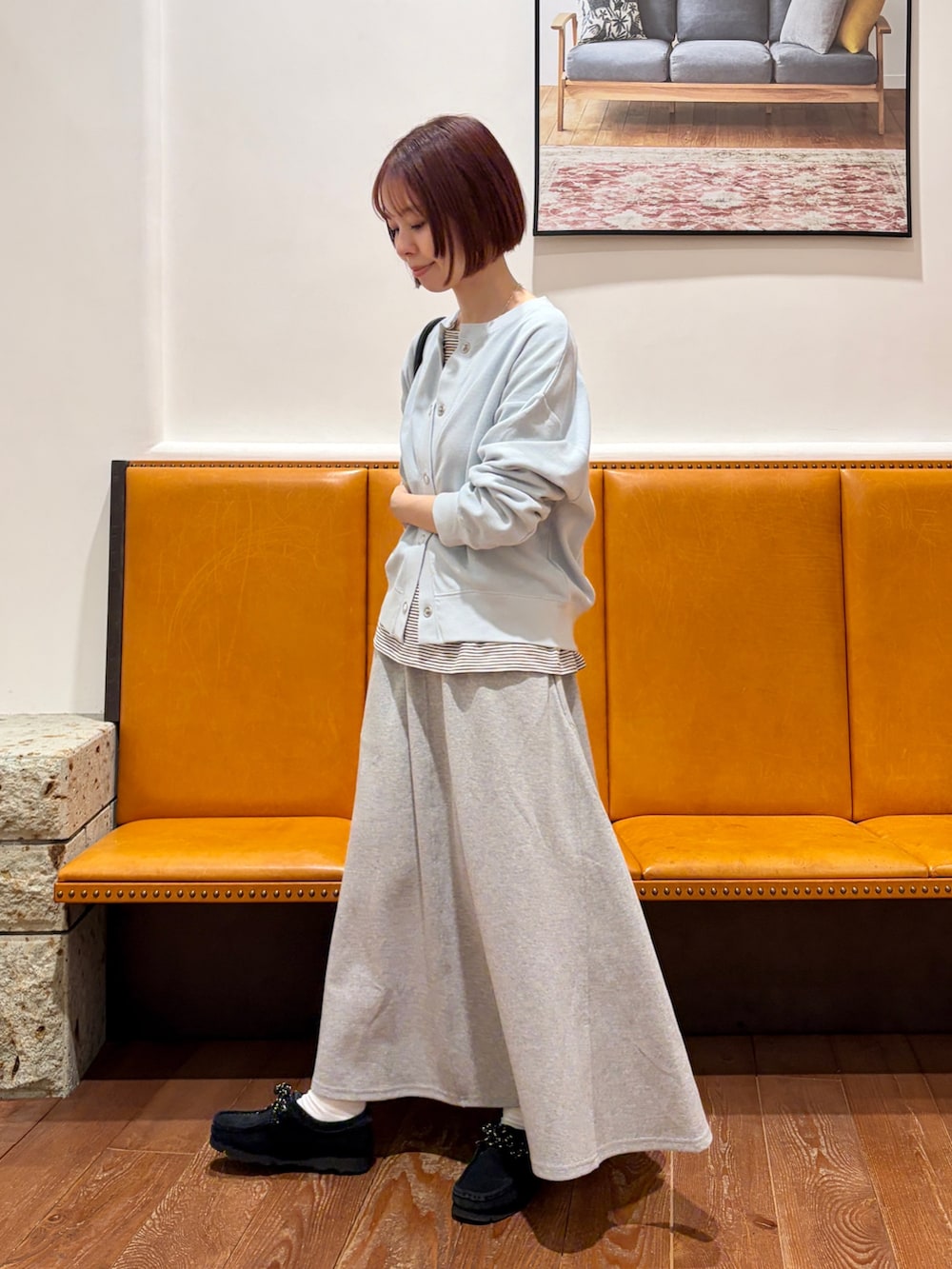 ブルー系のカーディガン/ボレロ、ベージュ系のTシャツ/カットソー、グレー系のスカートを着用したレディースの春コーディネートの3枚目の写真