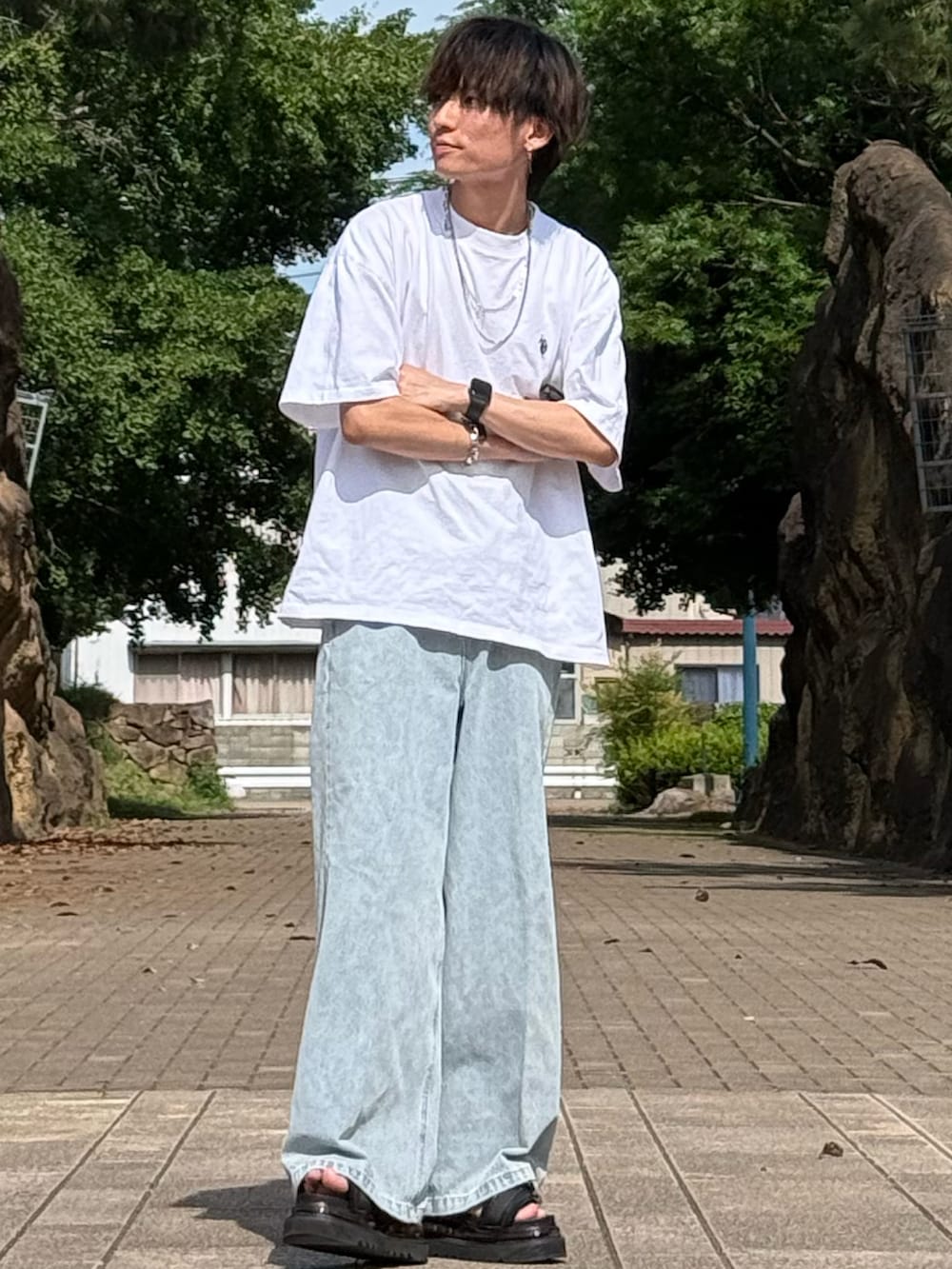 ホワイト系のTシャツ/カットソー、ブラック系のデニムパンツ、ブラック系のサンダルを着用したメンズの夏コーディネートの2枚目の写真