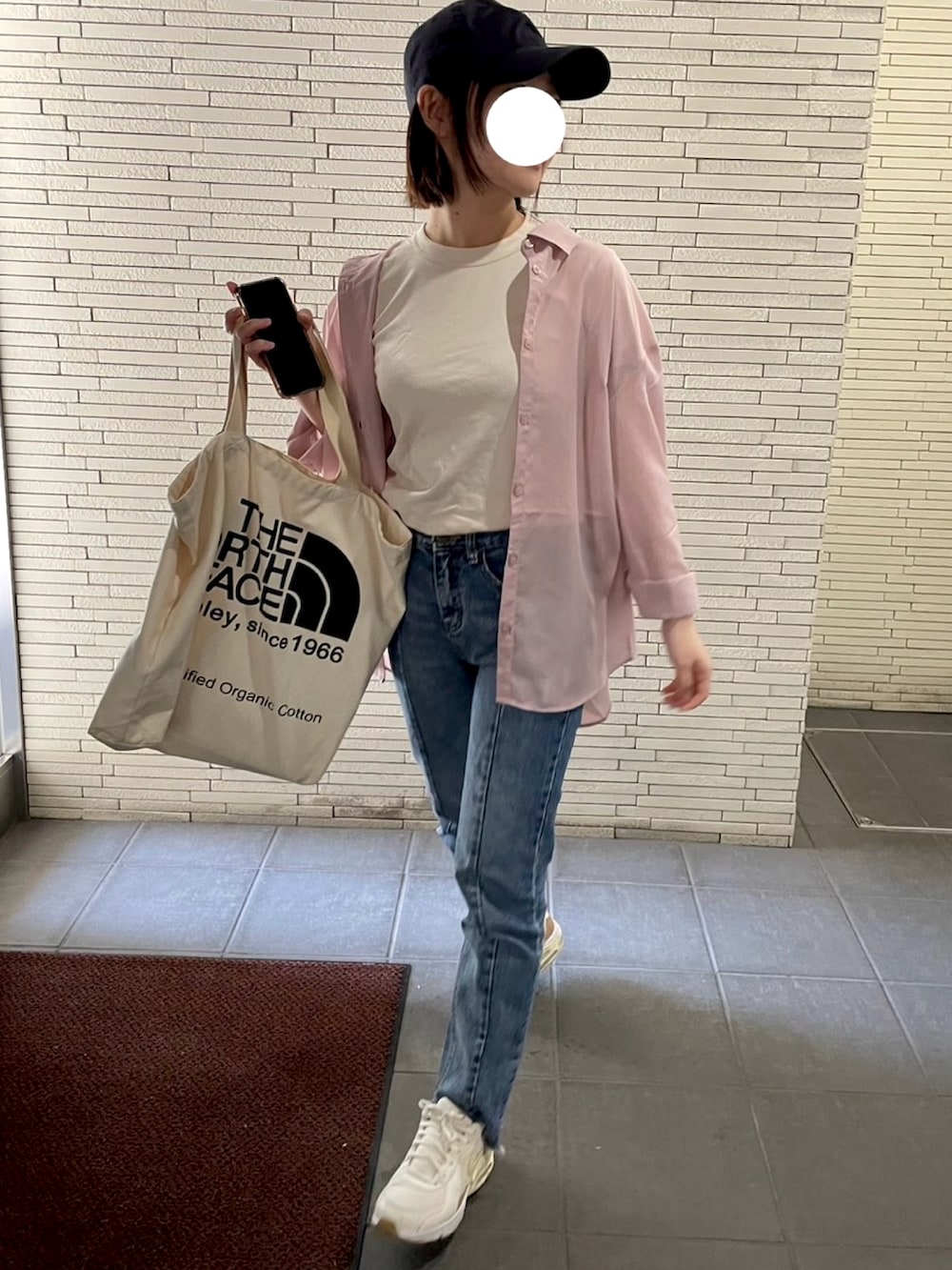 ピンク系のシャツ/ブラウス、ブルー系のデニムパンツ、ベージュ系のスニーカーを着用したレディースの春コーディネートの2枚目の写真