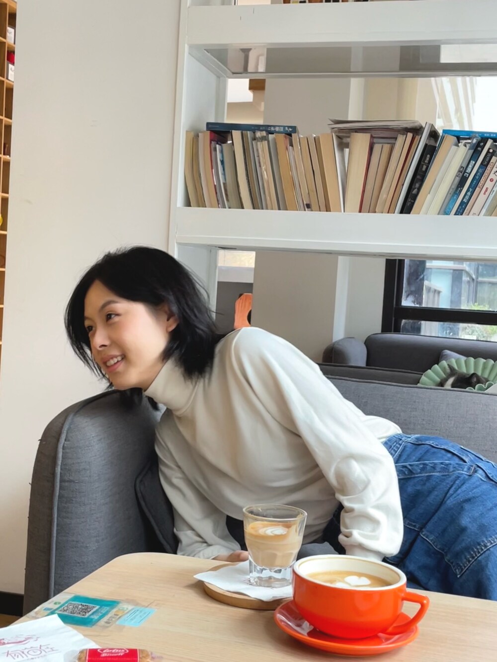 ホワイト系のニット/セーター、ブルー系のデニムパンツを着用したレディースの春コーディネートの2枚目の写真