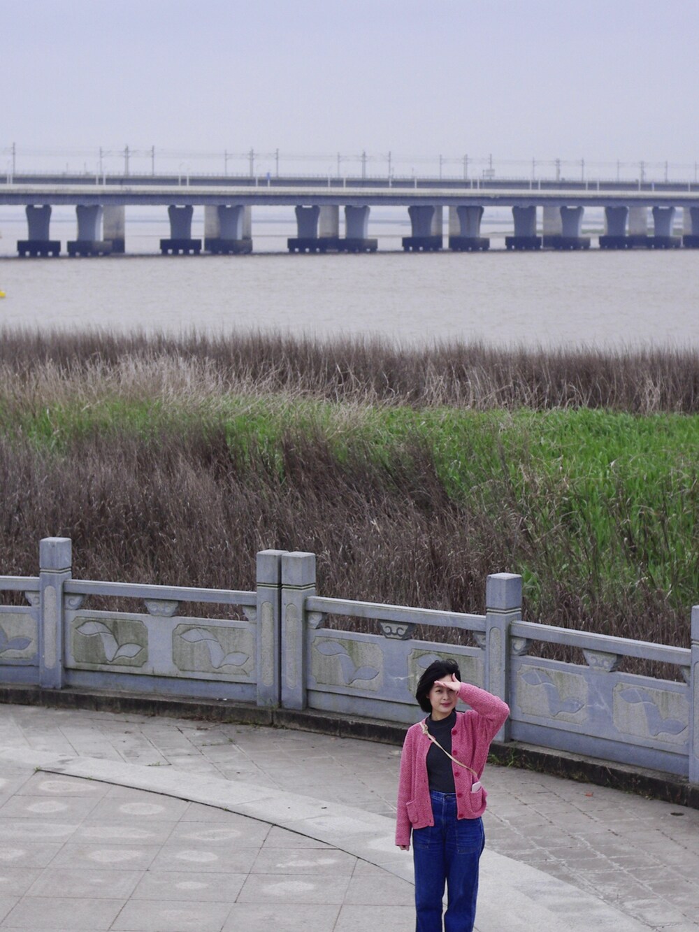 ブルー系のデニムパンツ、ピンク系のトップスを着用したレディースの春コーディネートの2枚目の写真