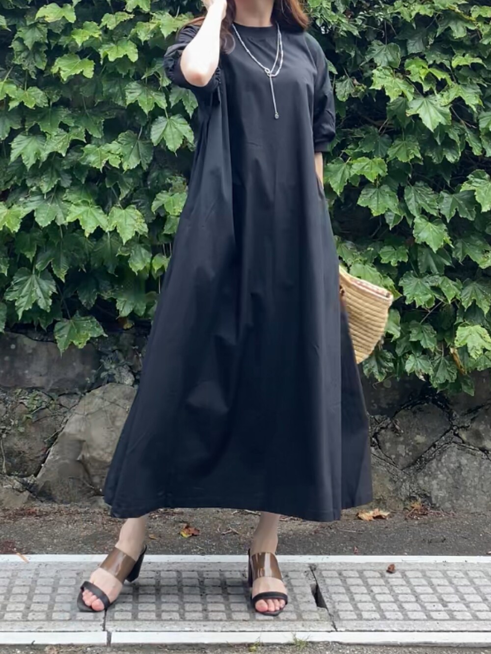 ブラック系のワンピースを着用したレディースの夏コーディネートの2枚目の写真