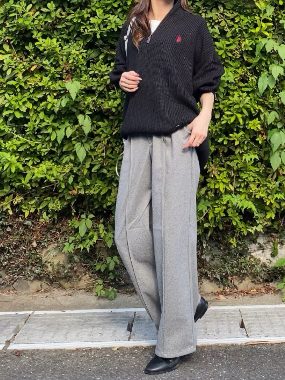 ブラック系のニット/セーター、ベージュ系のパンツを着用したレディースの秋コーディネートの2枚目の写真