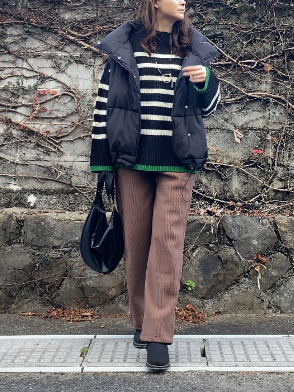 ブラウン系のその他パンツ、ブラック系のニット/セーター、ブラック系のバッグを着用したレディースの冬コーディネートの2枚目の写真